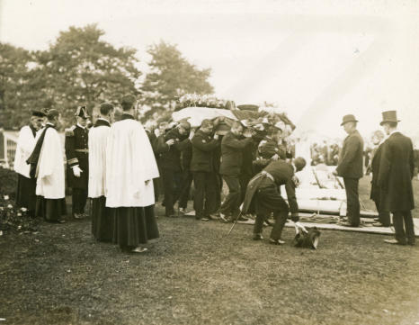 The arrival at the graveside of the coffin.